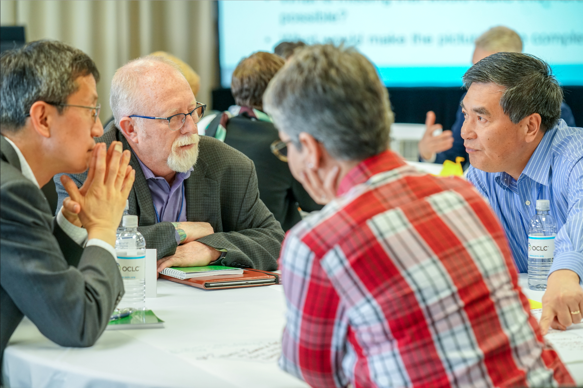 A group of people around a table having a discussion.