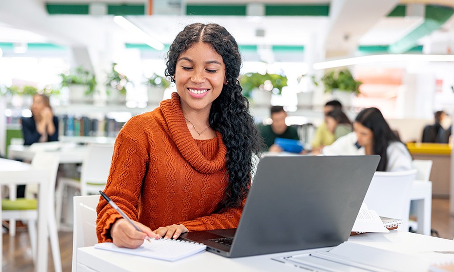 Student in library working on laptop