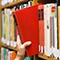 Bibliotheksbenutzer zieht ein Buch aus einem Regal