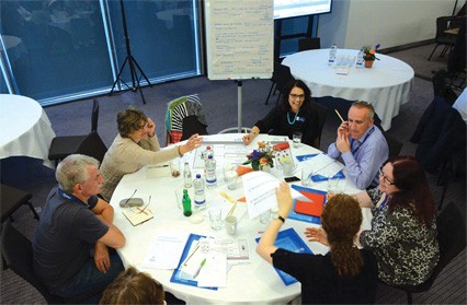 We move forward with purpose. Group meets around a table