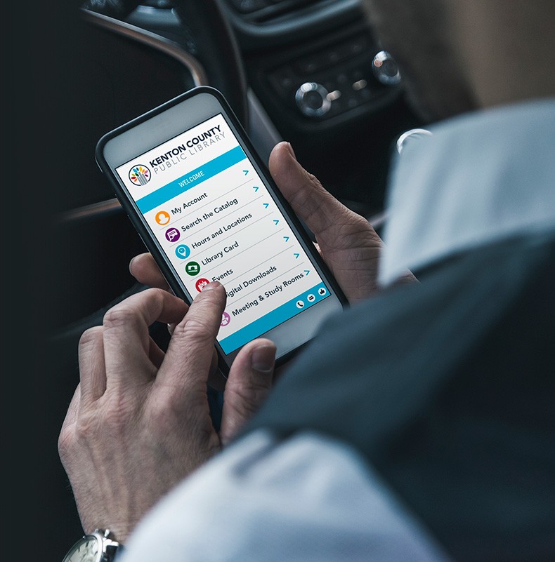 Photo: Man in car using Capira library interface on smartphone