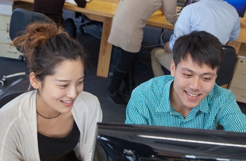 Male and female students looking at computer