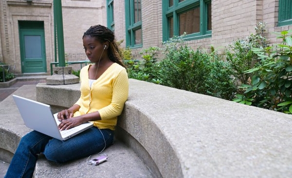 Student studying on laptop outside