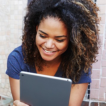 Photo: Woman reading article on laptop