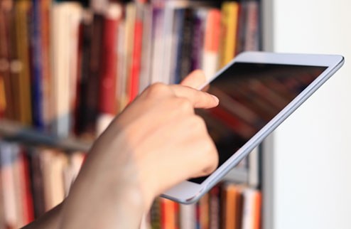 Person using a tablet in a library Person using a tablet in a library