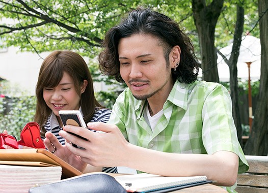 Estudiantes universitarios estudiando con un teléfono inteligente