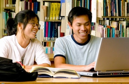 Estudiantes asiáticos utilizando una computadora portátil