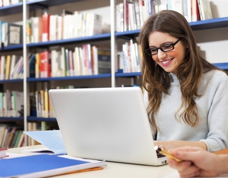 Una estudiante con una computadora en una biblioteca