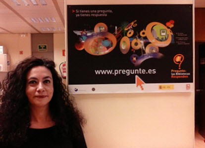María Isabel Cuadrado Fernández con un cartel publicitario para el servicio Pregunte