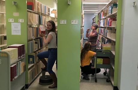 Personal de la biblioteca ubicando libros en los estantes durante la renovación
