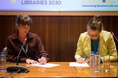 Foto van Erna Winter (president van EBLIDA) en Saskia Leferink (algemeen manager, OCLC Benelux) die het akkoord ondertekenen tijdens de EBLIDA-conferentie in Lissabon, Portugal, in april 2024.