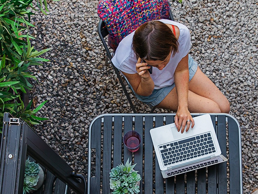 Photo: Woman using laptop on home patio